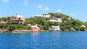 Disney Cruise Line NY Sailings Bermuda Cruises - A shoreline pressed up against a grassy hill with buildings and trees