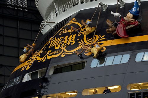 (OCTOBER 30, 2010): A shipyard worker stands under the giant sculpture of Mickey Mouse that hangs from the stern of the Disney Dream cruise ship on Oct. 30, 2010 at the Meyer Werft shipyard in Papenburg, Germany. The new ship made its first public appearance Oct. 30, 2010 as it was pulled by a tugboat out of an enclosed building dock at the Meyer Werft shipyard. Thousands of local residents gathered to see the "float out" ceremony. The new ship is scheduled to sail its maiden voyage Jan. 26, 2011 from Port Canaveral, Fla. (Diana Zalucky, photographer)